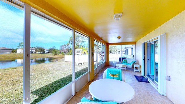 sunroom with a water view and a healthy amount of sunlight