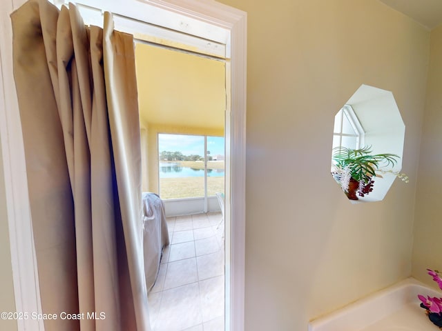 interior space featuring light tile patterned floors and a water view