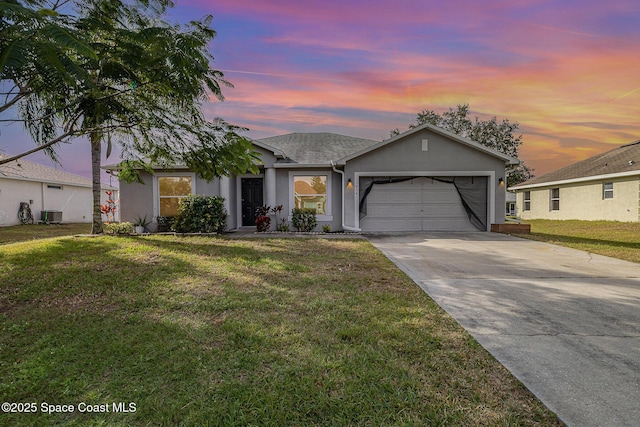 view of front of home with a lawn, central air condition unit, and a garage