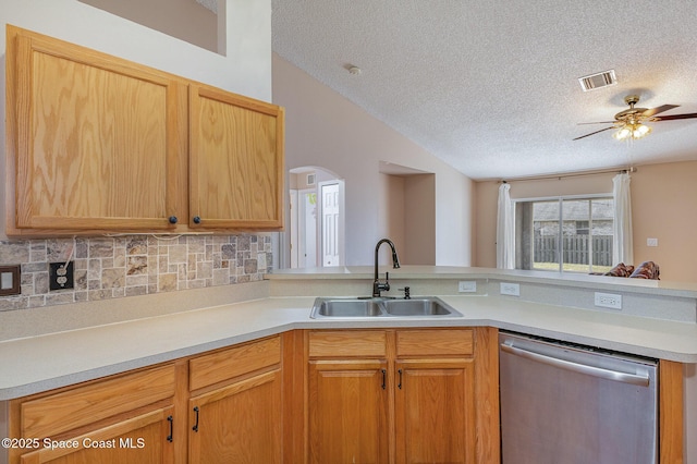 kitchen with kitchen peninsula, ceiling fan, dishwasher, a textured ceiling, and sink