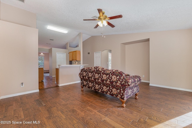 sitting room featuring ceiling fan, vaulted ceiling, a textured ceiling, and hardwood / wood-style flooring