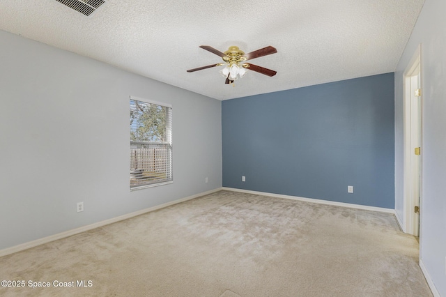 carpeted spare room featuring ceiling fan and a textured ceiling