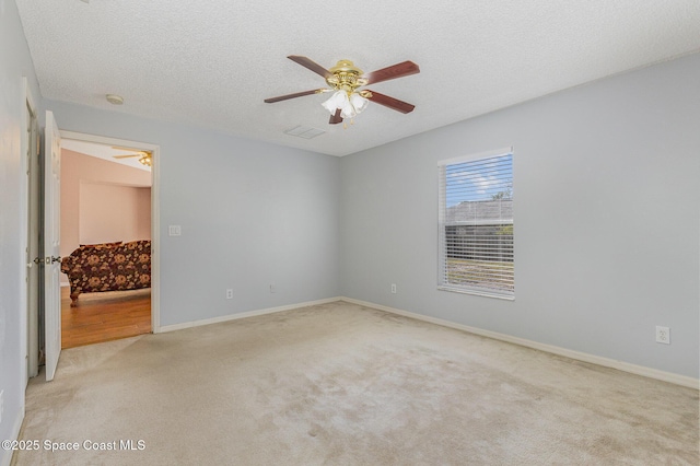 carpeted spare room with ceiling fan and a textured ceiling