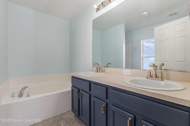 bathroom featuring tiled bath, tile patterned floors, and vanity