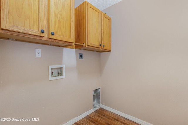 laundry room with a textured ceiling, cabinets, electric dryer hookup, hookup for a washing machine, and hardwood / wood-style flooring