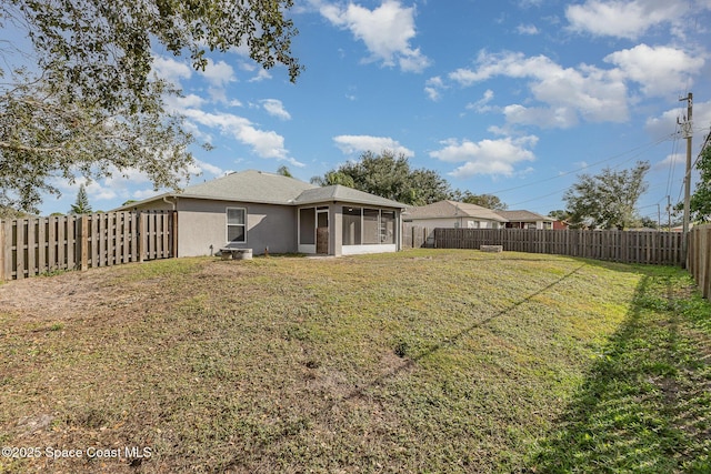 back of property featuring a sunroom and a yard