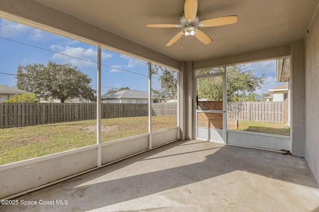 unfurnished sunroom featuring ceiling fan and a healthy amount of sunlight