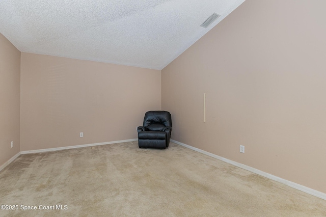 unfurnished room featuring a textured ceiling and light colored carpet