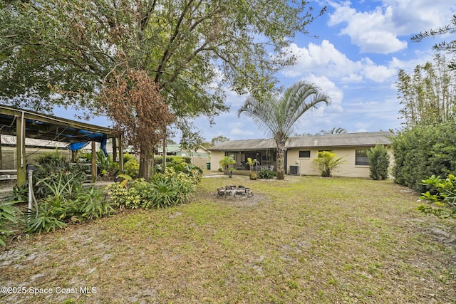 view of yard with central AC and a fire pit