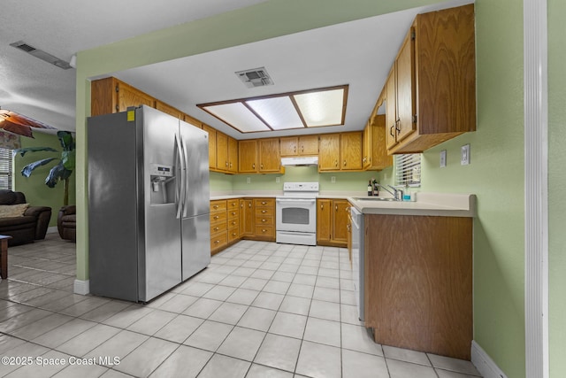 kitchen featuring sink, white appliances, and light tile patterned flooring