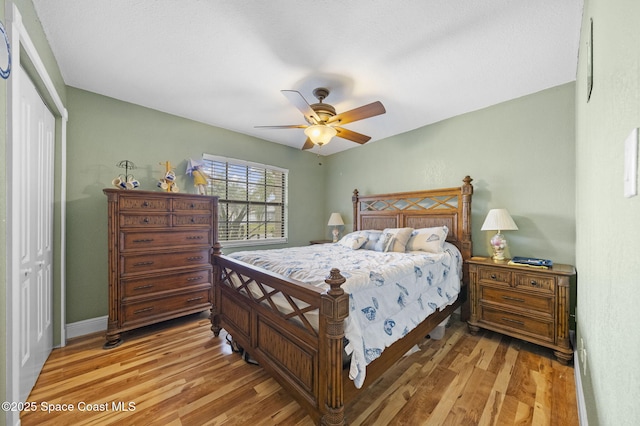 bedroom with ceiling fan, a closet, and light hardwood / wood-style floors