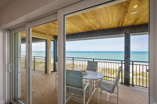 balcony with a water view and a beach view