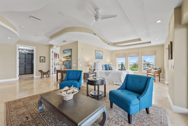 living room featuring ceiling fan with notable chandelier and a raised ceiling