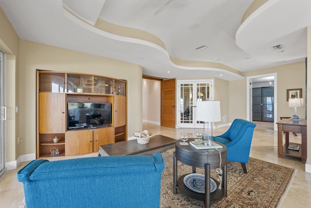 living room featuring french doors and a tray ceiling