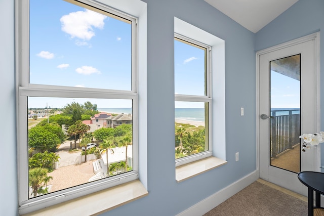 doorway featuring a water view, vaulted ceiling, and carpet