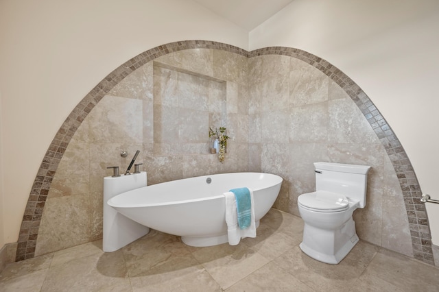 bathroom with tile walls, toilet, and a bathing tub