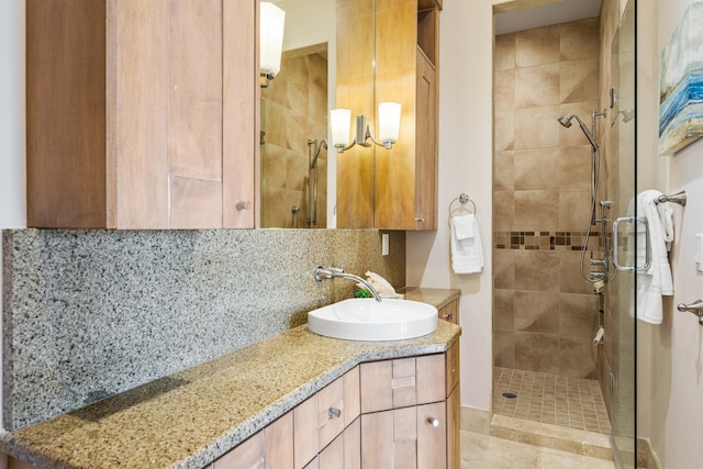 bathroom featuring a shower with shower door, backsplash, and vanity