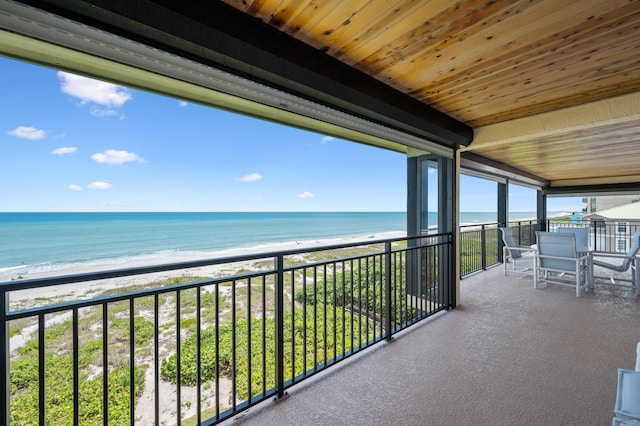 balcony with a water view and a beach view