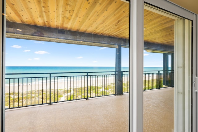 balcony featuring a view of the beach and a water view