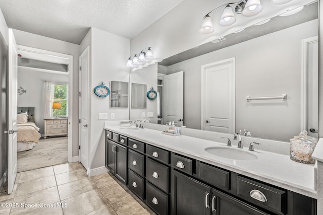 bathroom featuring tile patterned flooring, vanity, and a textured ceiling