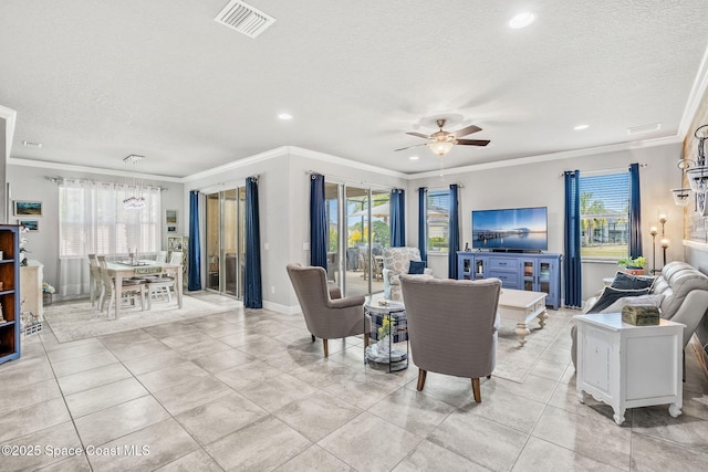 tiled living room featuring ceiling fan, ornamental molding, and a textured ceiling