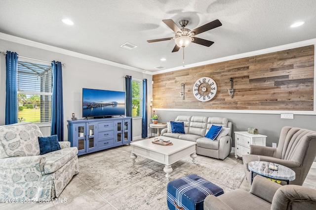 living room featuring wooden walls, ornamental molding, a textured ceiling, and light tile patterned flooring