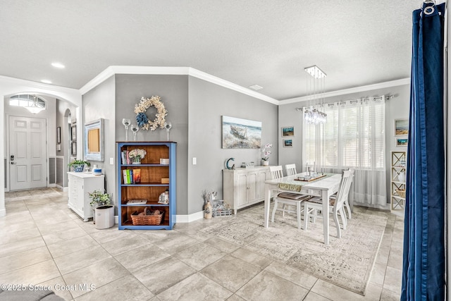 dining area with ornamental molding, light tile patterned flooring, and a textured ceiling