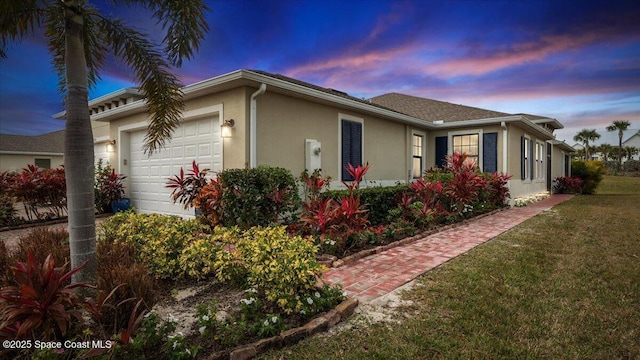 property exterior at dusk featuring a lawn and a garage