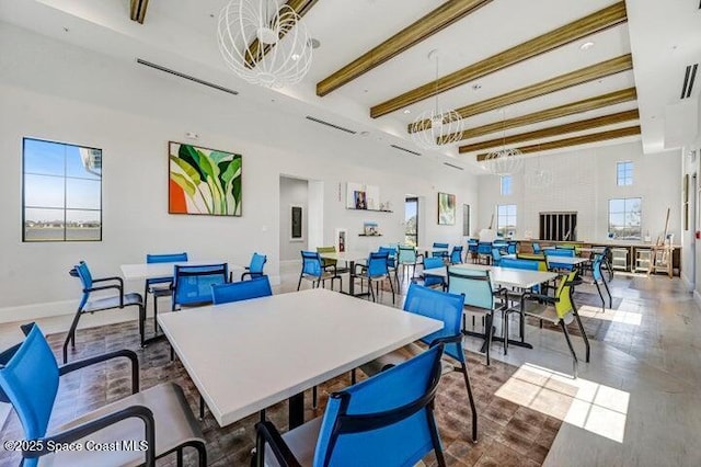 dining space with a fireplace and beamed ceiling