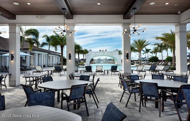 view of patio with a community pool and a water view