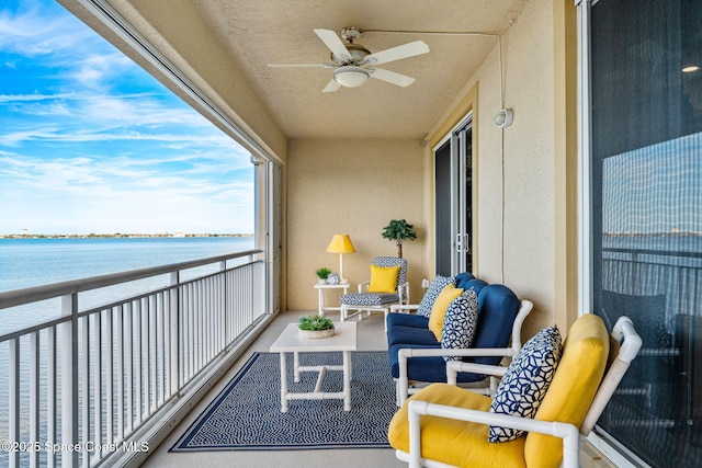 balcony featuring a water view and ceiling fan