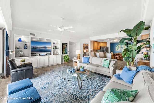 living room featuring crown molding and ceiling fan