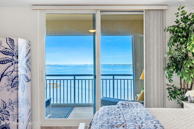 bedroom with a water view and multiple windows