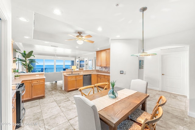 tiled dining room with ceiling fan and sink