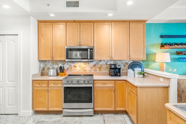 kitchen featuring tasteful backsplash, light tile patterned floors, and appliances with stainless steel finishes