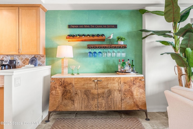 bar featuring dark tile patterned floors and decorative backsplash