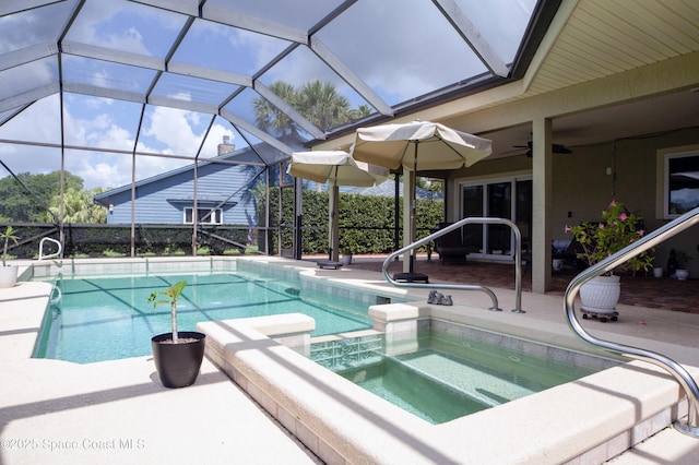 view of pool with a lanai, ceiling fan, a patio area, and an in ground hot tub