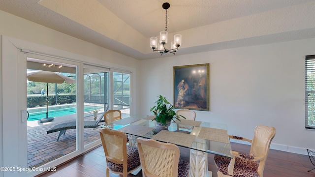 dining space featuring a textured ceiling, an inviting chandelier, and dark hardwood / wood-style floors