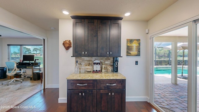 bar with a healthy amount of sunlight, decorative backsplash, dark wood-type flooring, and dark brown cabinetry