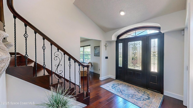 foyer featuring a textured ceiling, dark hardwood / wood-style flooring, and vaulted ceiling