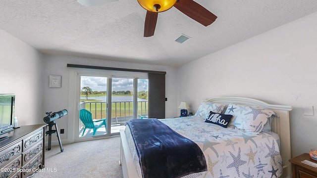 bedroom with light carpet, ceiling fan, access to exterior, and a textured ceiling