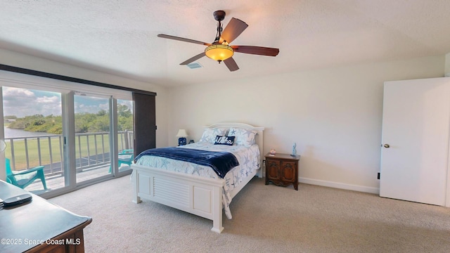 carpeted bedroom with a textured ceiling, ceiling fan, and access to exterior