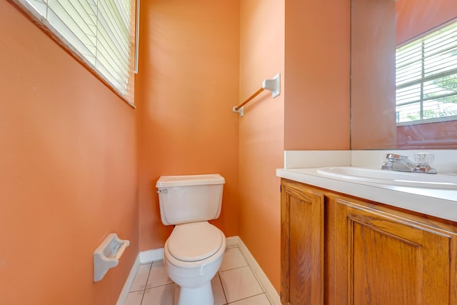 bathroom with toilet, vanity, and tile patterned flooring