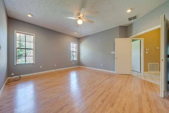 unfurnished room featuring a textured ceiling, ceiling fan, and light hardwood / wood-style flooring