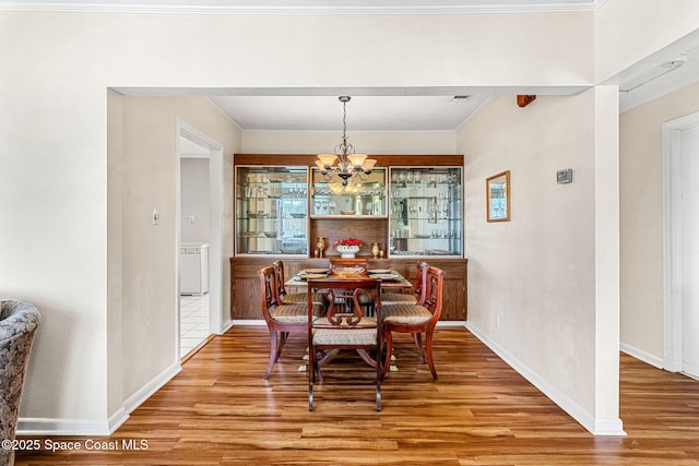 dining room with hardwood / wood-style flooring and a notable chandelier