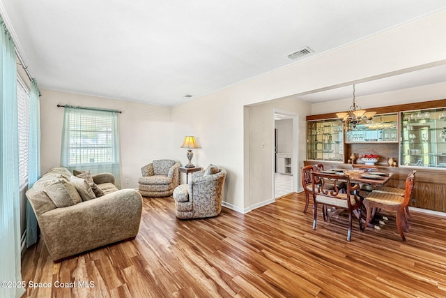 living room featuring light hardwood / wood-style floors and a notable chandelier