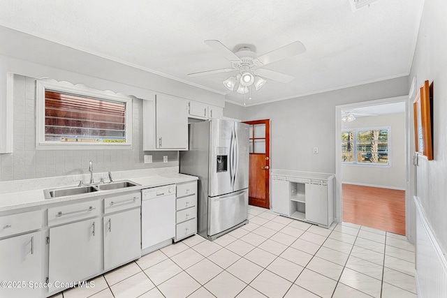 kitchen featuring white cabinetry, stainless steel refrigerator with ice dispenser, light tile patterned flooring, white dishwasher, and sink