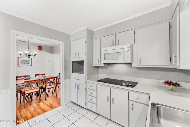 kitchen with pendant lighting, white cabinetry, a notable chandelier, light tile patterned flooring, and black electric cooktop