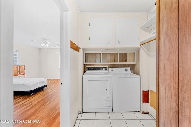 laundry room with ceiling fan, light tile patterned floors, washer and dryer, and cabinets