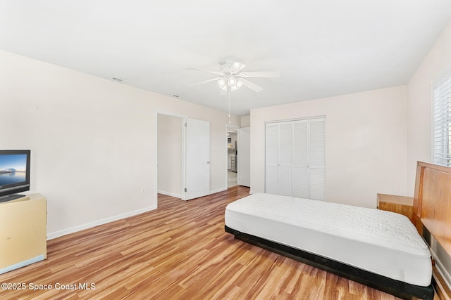 bedroom featuring ceiling fan, a closet, and light hardwood / wood-style floors